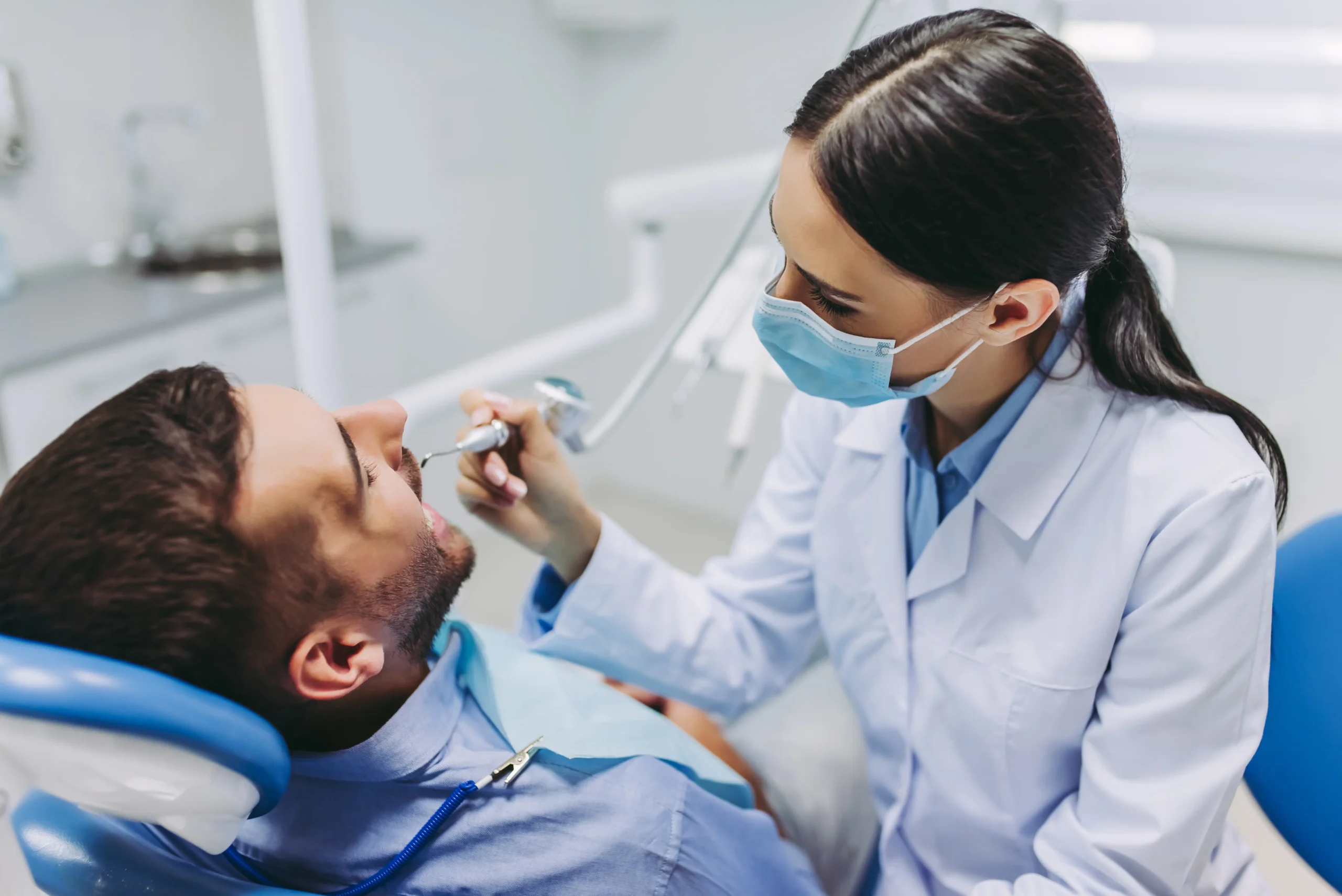 portrait-female-doctor-treating-male-patient-teeth-modern-dental-clinic